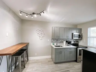 a kitchen with gray cabinets and a wooden counter top at Rustic Retreats Cozy 1BR for 4 guests minutes from Las Olas in Fort Lauderdale