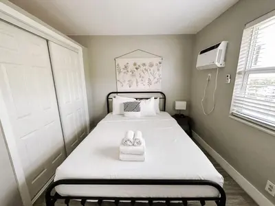 a small bedroom with a bed with a white blanket at Rustic Retreats Cozy 1BR for 4 guests minutes from Las Olas in Fort Lauderdale