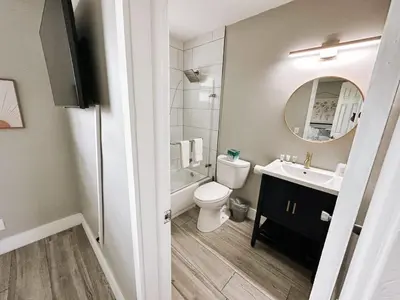 a bathroom with a toilet and a sink and a mirror at Rustic Retreats Cozy 1BR for 4 guests minutes from Las Olas in Fort Lauderdale