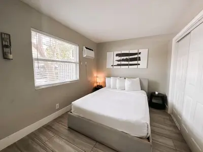 a bedroom with a white bed and a window at Rustic Retreats Cozy 1BR For 4 Guests Minutes From Las Olas in Fort Lauderdale