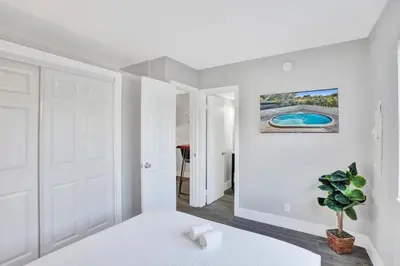 a white bedroom with a bed and a plant at Rustic Retreats Beachy 1BR for 4 guests in the heart of Fort Lauderdale in Fort Lauderdale