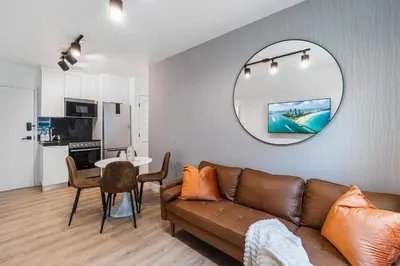 a living room with a brown couch and a mirror at Lux Retreat By Renzzi in Miami
