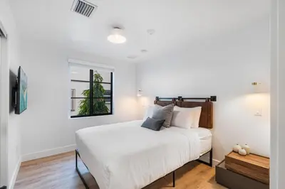 a white bedroom with a large bed with white sheets at Lux Retreat By Renzzi in Miami