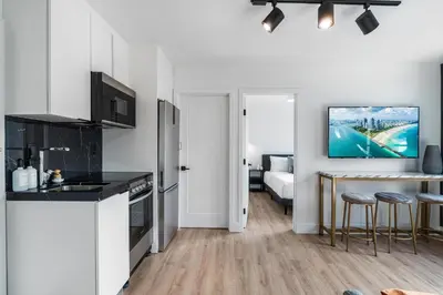 a white kitchen with a sink and a stove at Lux Retreat By Renzzi in Miami