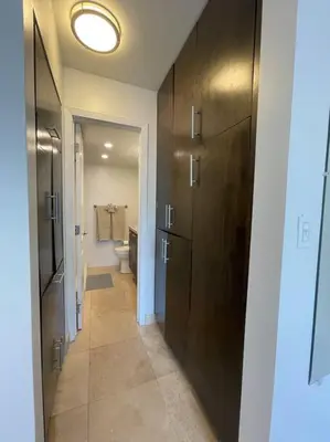 a bathroom with a toilet and a large wooden door at South Beach Escape in Miami Beach