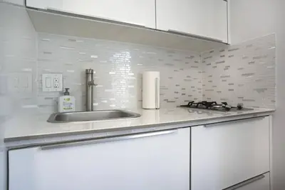 a kitchen with white cabinets and a sink at Miami Beach Getaway 100 yards from Beach in Miami Beach