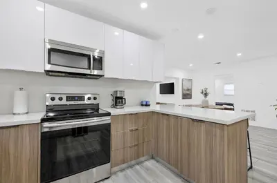 a kitchen with a stove and a microwave at Modern villa in Design District ! in Miami