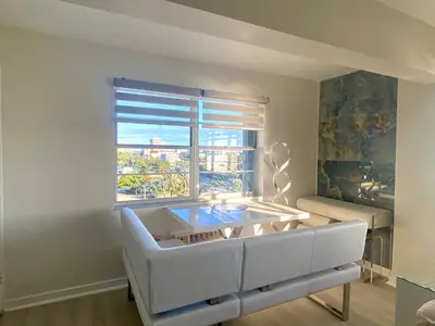 a living room with a white couch and a window at Panoramic luxurious waterfront one bedroom apartment with Miami skyline view Free parking 5min drive to Miami Beach in Miami Beach