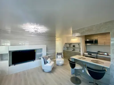 a living room with a kitchen with a large television at Panoramic luxurious waterfront one bedroom apartment with Miami skyline view Free parking 5min drive to Miami Beach in Miami Beach