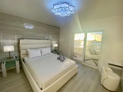a bedroom with a large bed and a chandelier at Panoramic luxurious waterfront one bedroom apartment with Miami skyline view Free parking 5min drive to Miami Beach in Miami Beach