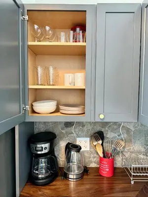 a kitchen cabinet with dishes and a coffee maker at Directly on the Beach with Pool & Parking in Miami Beach