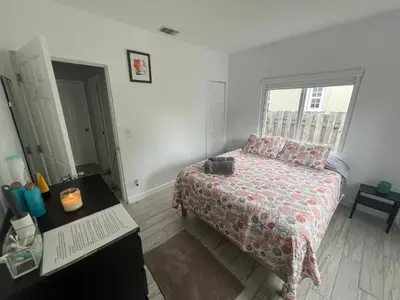a bedroom with a bed and a desk and a window at Cozy room in a quiet home in Miami