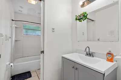 a white bathroom with a sink and a shower at Crocodhouse early check in eight years hosting in Fort Lauderdale