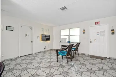 a room with a table and chairs and a tv at Crocodhouse early check in eight years hosting in Fort Lauderdale