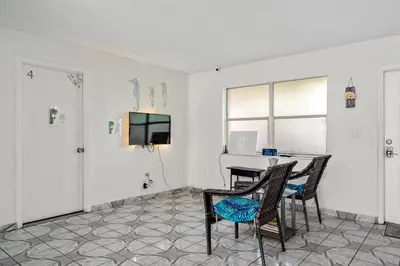 a room with a table and chairs and a television at Crocodhouse early check in eight years hosting in Fort Lauderdale