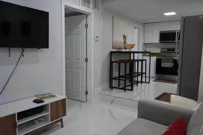 a living room with a couch and a tv and a kitchen at Charming two bedroom apartment. in Miami