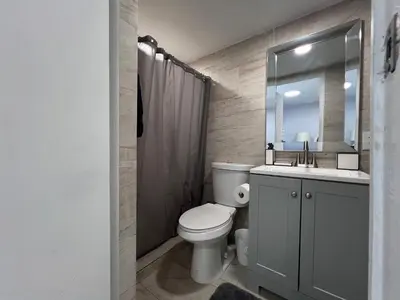 a bathroom with a toilet and a sink and a mirror at Charming two bedroom apartment. in Miami