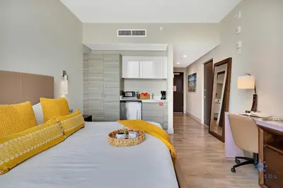 a living room with a large bed and a kitchen at Costa Hollywood Beach in Hollywood