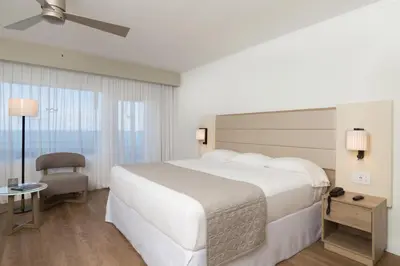 a hotel room with a large white bed and a window at Riu Plaza Miami Beach in Miami Beach