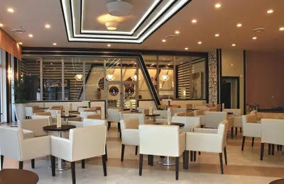 a restaurant with white chairs and tables at Riu Plaza Miami Beach in Miami Beach
