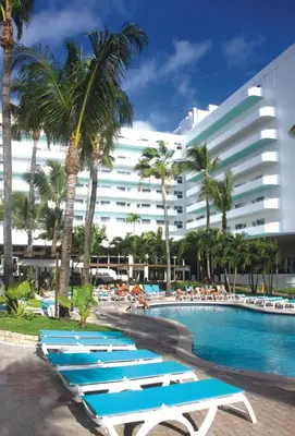 a row of lounge chairs next to a swimming pool at Riu Plaza Miami Beach in Miami Beach
