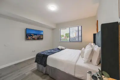 a bedroom with a large bed with a tv on the wall at Prime Location Apt on Calle Ocho in Little Havana in Miami