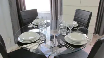 a glass table with chairs and plates and wine glasses at Ocean Dream by the Beach in Miami Beach