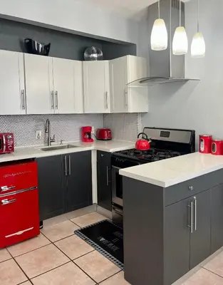 a kitchen with black and white cabinets and red appliances at Ocean Dream by the Beach in Miami Beach