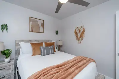 a bedroom with a large white bed with a fan at New! Miami & Calle Ocho Simpson's Funhouse! in Miami