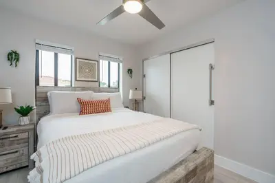 a bedroom with a large white bed with a ceiling fan at New! Miami & Calle Ocho Simpson's Funhouse! in Miami