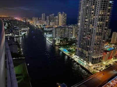 a view of a city at night with a river at Cozy Beach Apartment with Full Kitchen & Ocean Views in Hallandale Beach