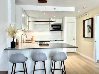 a kitchen with two bar stools and a counter at High-End remodeled apartment, On the Beach in Miami Beach