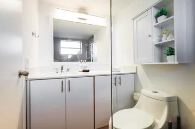 a bathroom with a toilet and a sink and a mirror at La Marinita - Marina Views Pool Parking Location in Miami Beach