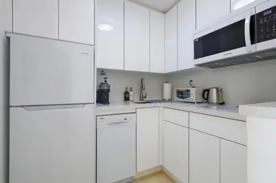 a white kitchen with white cabinets and appliances at La Marinita - Marina Views Pool Parking Location in Miami Beach