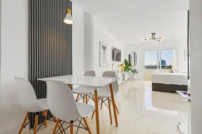 a white dining room with a white table and white chairs at La Marinita - Marina Views Pool Parking Location in Miami Beach
