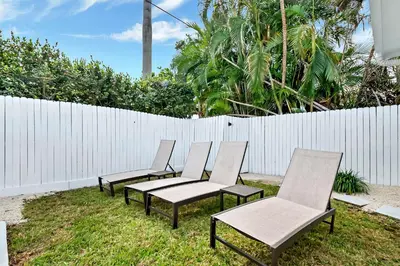 a group of chairs sitting in the grass next to a fence at Casa Azul 4Bed 2Bath Home with Heated Pool & Spa 1304 in Hollywood