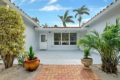 a white house with plants in a courtyard at Casa Azul 4Bed 2Bath Home with Heated Pool & Spa 1304 in Hollywood