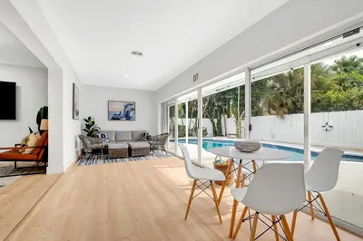 a living room with a table and chairs and a pool at Casa Azul 4Bed 2Bath Home with Heated Pool & Spa 1304 in Hollywood