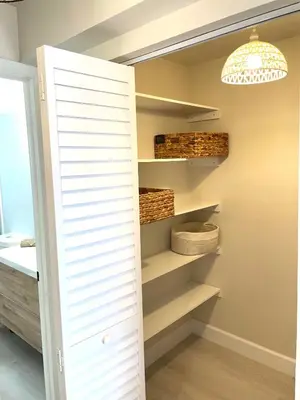 a closet with shelves and a chandelier at Zen Vibe on the Beach /700 SqFt in Miami Beach