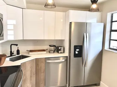a kitchen with a stainless steel refrigerator and white cabinets at Zen Vibe on the Beach /700 SqFt in Miami Beach