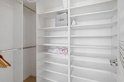 a walk in closet with white shelves at Quiet & central Apt in Midtown Miami in Miami