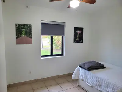 a bedroom with a bed and a window at Cozy family home in quiet area, nice garden views. in Tamiami