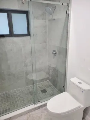 a bathroom with a glass shower with a toilet at Cozy family home in quiet area, nice garden views. in Tamiami