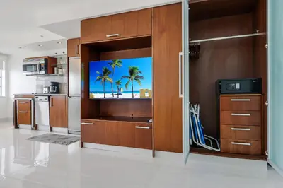 a kitchen with a flat screen tv on a wall at Strand Ocean Drive Suites in Miami Beach