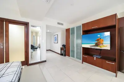 a bedroom with a flat screen tv on a wall at Strand Ocean Drive Suites in Miami Beach