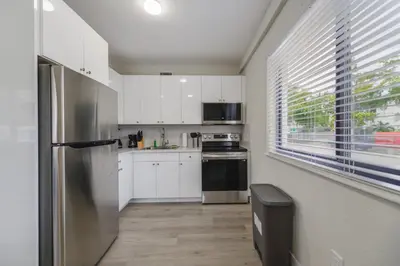 a kitchen with white cabinets and a stainless steel refrigerator at Heart of Little Havana Awaits in Miami