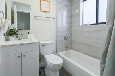 a white bathroom with a toilet and a tub and a sink at Amazing Experience in Calle Ocho in Miami