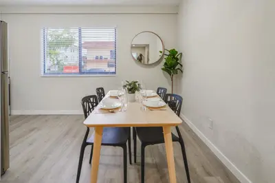 a dining room with a table with chairs and a mirror at Amazing Experience in Calle Ocho in Miami