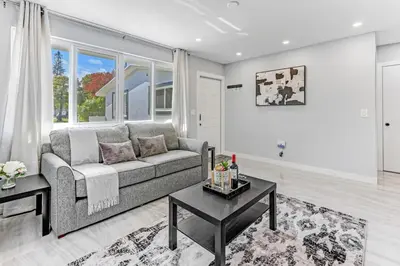 a living room with a couch and a table at Hallandale Collection - Renovated Professional Design & Lake View in Ro-Len Lake Gardens