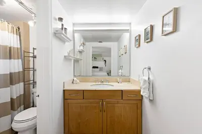 a bathroom with a sink and a toilet and a mirror at Charming Apartment near Las Olas Blvd in Fort Lauderdale